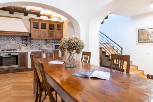 a kitchen with a wooden table with a vase of flowers at Casa Cennano in Montevarchi
