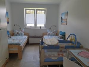 a room with two beds and a table at Haus Seestern in Walchum