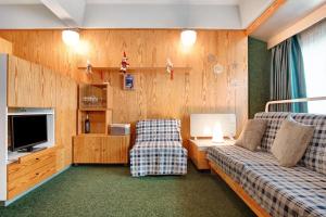 a living room with two couches and a television at Appartamento Nives in Marilleva