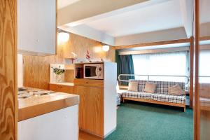 a kitchen with a microwave and a couch in a room at Appartamento Nives in Marilleva