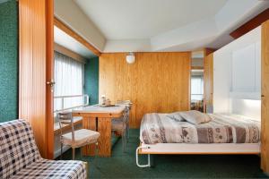 a bedroom with a bed and a desk and a sink at Appartamento Nives in Marilleva +21 photos
