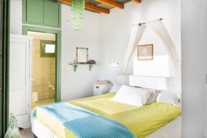 a bedroom with a bed in a room with green and white walls at Paros - Sikinos Sunset in Sikinos
