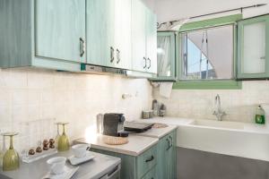 a kitchen with blue cabinets and a sink and a counter at Paros - Sikinos Sunset in Sikinos