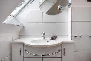 a white bathroom with a sink and a mirror at Bäckerhus - Ferienwohnung 4 in Wiek auf Rügen