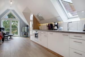 a kitchen with white cabinets and a large window at Bäckerhus - Ferienwohnung 4 in Wiek auf Rügen +16 photos