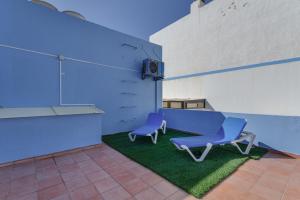 two blue chairs sitting on a patch of grass in a room at Casa Mar Azul Arinaga in Arinaga