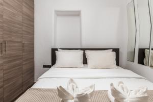 a bedroom with a bed with two white flowers on it at Sunset Horizon Villa in Mikonos