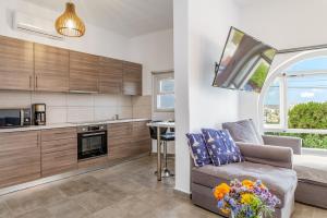 a living room with a couch and a kitchen at Sunset Horizon Villa in Mikonos