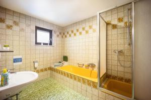 a bathroom with a yellow tub and a sink at Erkheim in Erkheim +10 photos