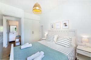 a white bedroom with a large bed with towels on it at Es Cos in Algaida +22 photos