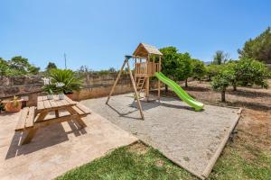 a playground with a slide and a swing set at Es Cos in Algaida