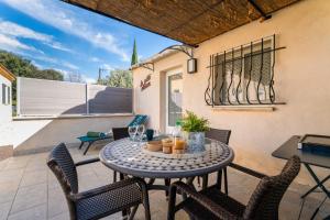 a patio with a table and chairs on a patio at La Petite Maison in Bédoin