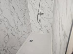 a white toilet in a bathroom with a marble wall at Haus am Goldberg in Tannheim