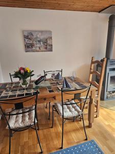 a dining room table with chairs and a vase of flowers at Haus am Goldberg in Tannheim