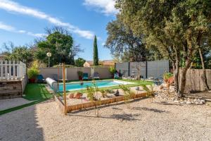 a backyard with a swimming pool and a fence at La Petite Maison in Bédoin