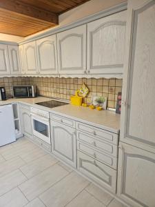 a kitchen with white cabinets and white appliances at Haus am Goldberg in Tannheim +8 photos