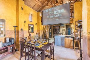 a dining room with a table and a tv at Casa Rural Ermita de las eras in Algarinejo