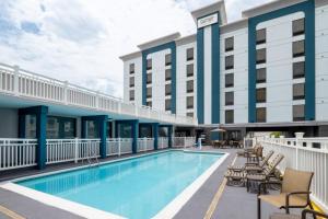 a hotel pool with chairs and a hotel at Garner Hotel Virginia Beach North by IHG in Virginia Beach
