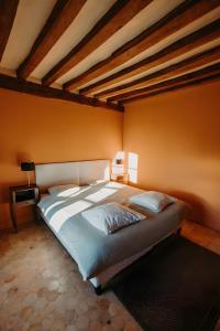 a large bed in a room with orange walls at La Maison de Melmont in Roumare