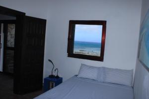 a bedroom with a bed and a mirror and the ocean at Casa Nostra in Pájara