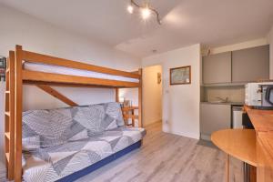 a small room with a bunk bed and a kitchen at Prapoutel pied des pistes in Les Adrets