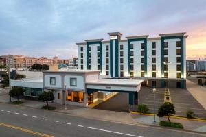 a large white building with a clock on top of it at Garner Hotel Virginia Beach North by IHG in Virginia Beach