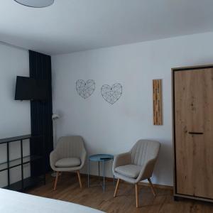 two chairs and a table in a room at Haus Moselliebe charmant zimmer in Ediger-Eller