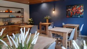 a dining room with two tables and blue walls at Haus Moselliebe charmant zimmer in Ediger-Eller