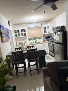 a kitchen with a table and chairs and a refrigerator at Cool Stay in Christ Church