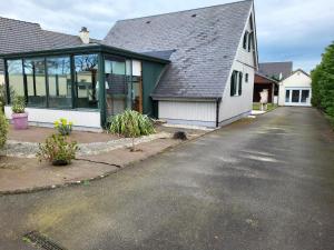 a house with a lot of windows and a driveway at Maison De Bord De Mer in Pirou