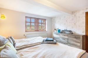 a bedroom with a bed and a dresser and a window at You R Welcome too in Frischborn