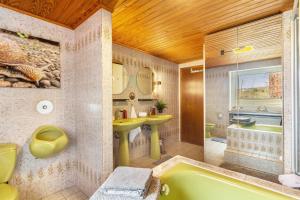 a bathroom with a green tub and a sink at You R Welcome too in Frischborn +23 photos