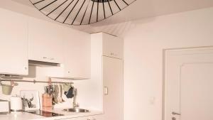 a kitchen with white cabinets and a ceiling at Ferienwohnung Lichtblick in Sattendorf +21 photos