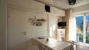 a white dining room with a table and a window at Ferienwohnung Lichtblick in Sattendorf