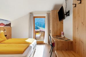 a hotel room with a bed and a window at Veltierhof Villnöß in Funes