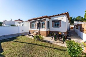 a house with a backyard with a table and chairs at Casa Thaiker in Miami Platja