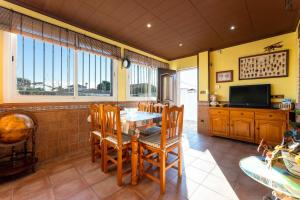 a dining room with a table and chairs and a television at Casa Thaiker in Miami Platja