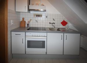 a kitchen with white cabinets and a sink at Ferienwohnung 'auf dem Burstel' in Kleines Wiesental