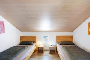 two beds in a small room with wooden ceilings at Ferienwohnung Beni in Öhningen