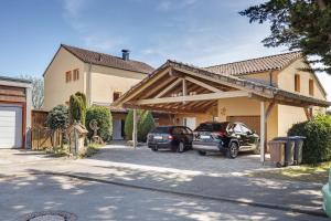 two cars parked in a parking lot in front of a house at Ferienwohnung Beni in Öhningen
