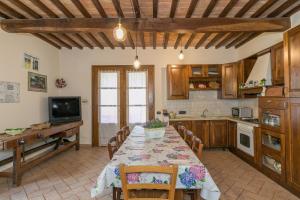 a kitchen with a table with chairs and a television at Stupendo rustico in pietra in Castellina Marittima