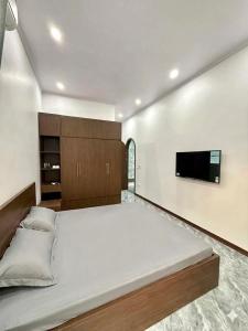 a large bedroom with a large bed and a flat screen tv at De Paris Homestay in Cửa Lô