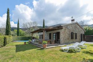 a stone house with a garden and a pool at Stupendo rustico in pietra in Castellina Marittima