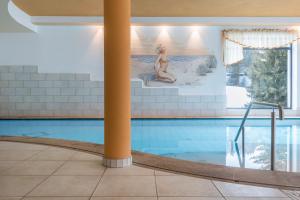 a swimming pool with a mermaid on the wall at Sabina Dolomites Santner in Alpe di Siusi