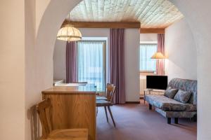 a living room with a table and a couch at Sabina Dolomites Santner in Alpe di Siusi