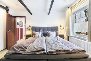 a bedroom with a large bed with pillows and a window at Ferienwohnung Küstenliebe in Lehe