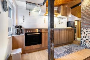 a kitchen with wooden cabinets and a stove at Ferienwohnung Küstenliebe in Lehe +16 photos