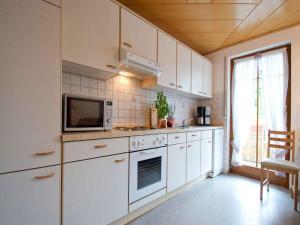 a kitchen with white cabinets and a microwave at Gästehaus Herrmann in Bad Rippoldsau-Schapbach +51 photos