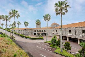 an exterior view of a building with palm trees at Toba Ocean Resort All-Inclusive Hotel in Toba