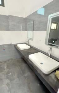 a bathroom with two sinks and a mirror at De Paris Homestay in Cửa Lô